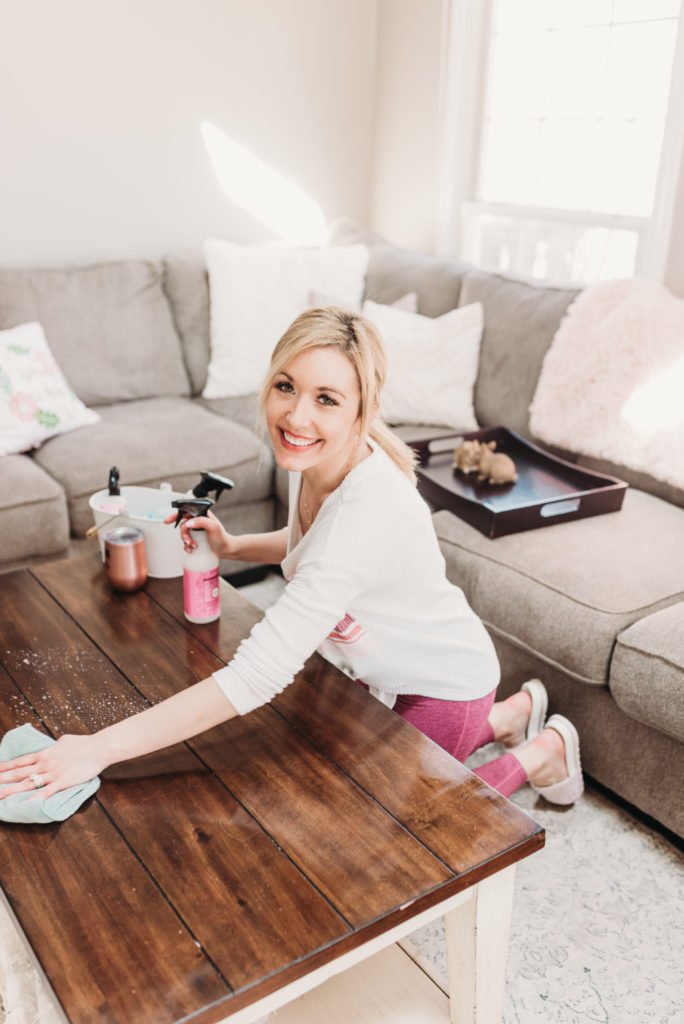 Brianna K cleaning a table in her family room with Mrs Meyers peony multi surface spray and cleaning motivation rose gold tumbler cup clean with me spring cleaning check list bits of bri blog 