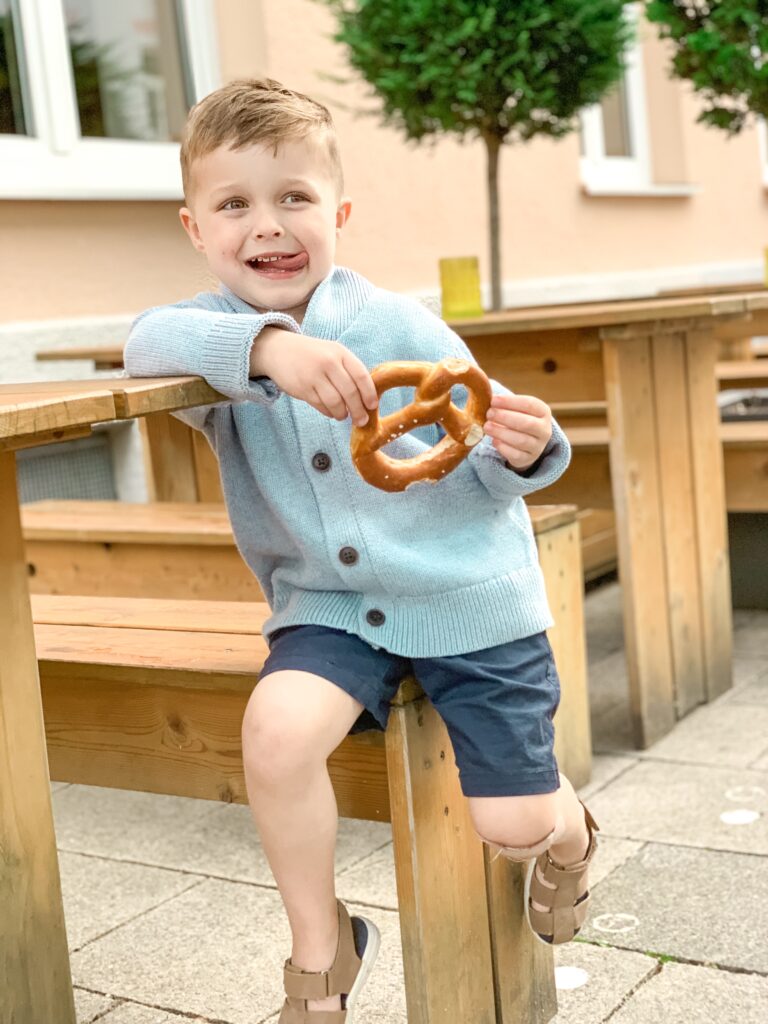 young boy Landon holding a pretzel on vacation in Munich, Germany Oktoberfest MUNICH, GERMANY TRAVEL DIARY | 4-DAY ITINERARY AND TRAVEL TIPS Brianna K bitsofbri young family traveling the world 