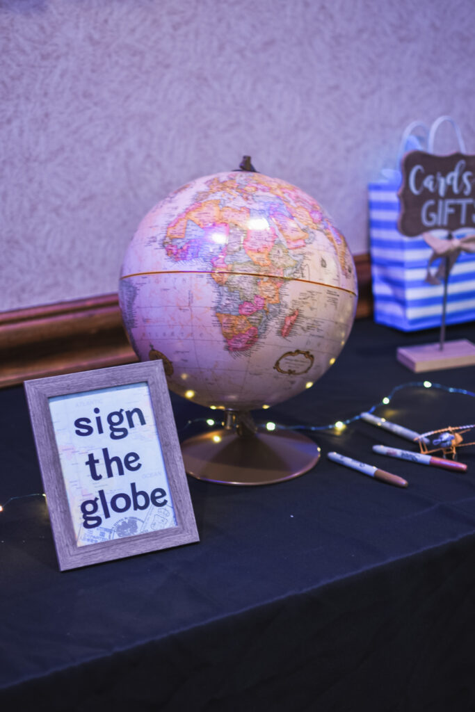 Sign the globe guestbook alternative at Saturday night reception globe and suitcase  centerpieces with luggage tag party favors travel theme party decor decorations for a travel themed around the world bar mitzvah celebration Brianna K bits of Bri party planner 
